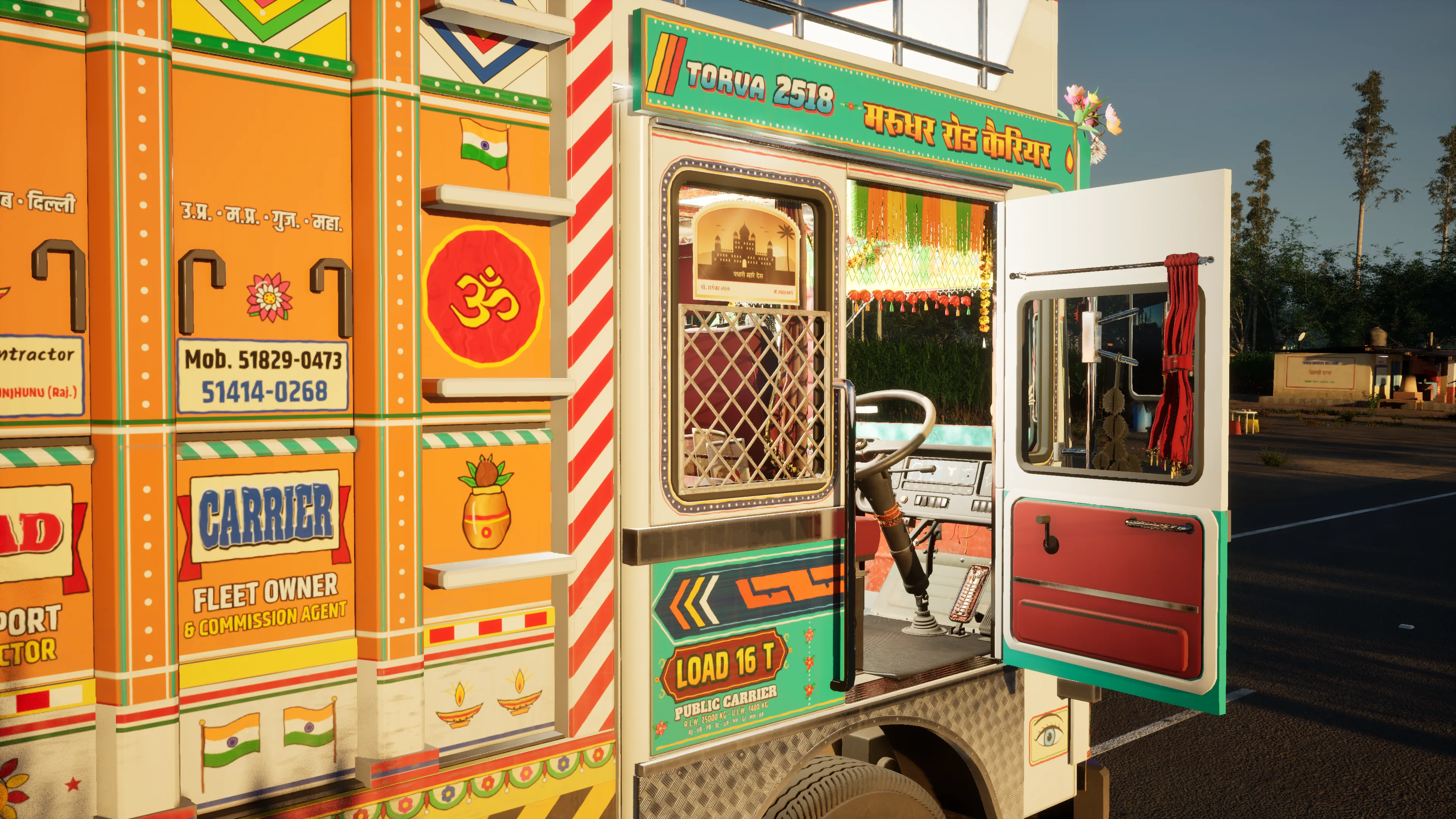 A parked truck in evening sun with its driver’s door open on a cab hung with fringe, the orange side painted with an Om, a kalash and Indian flags