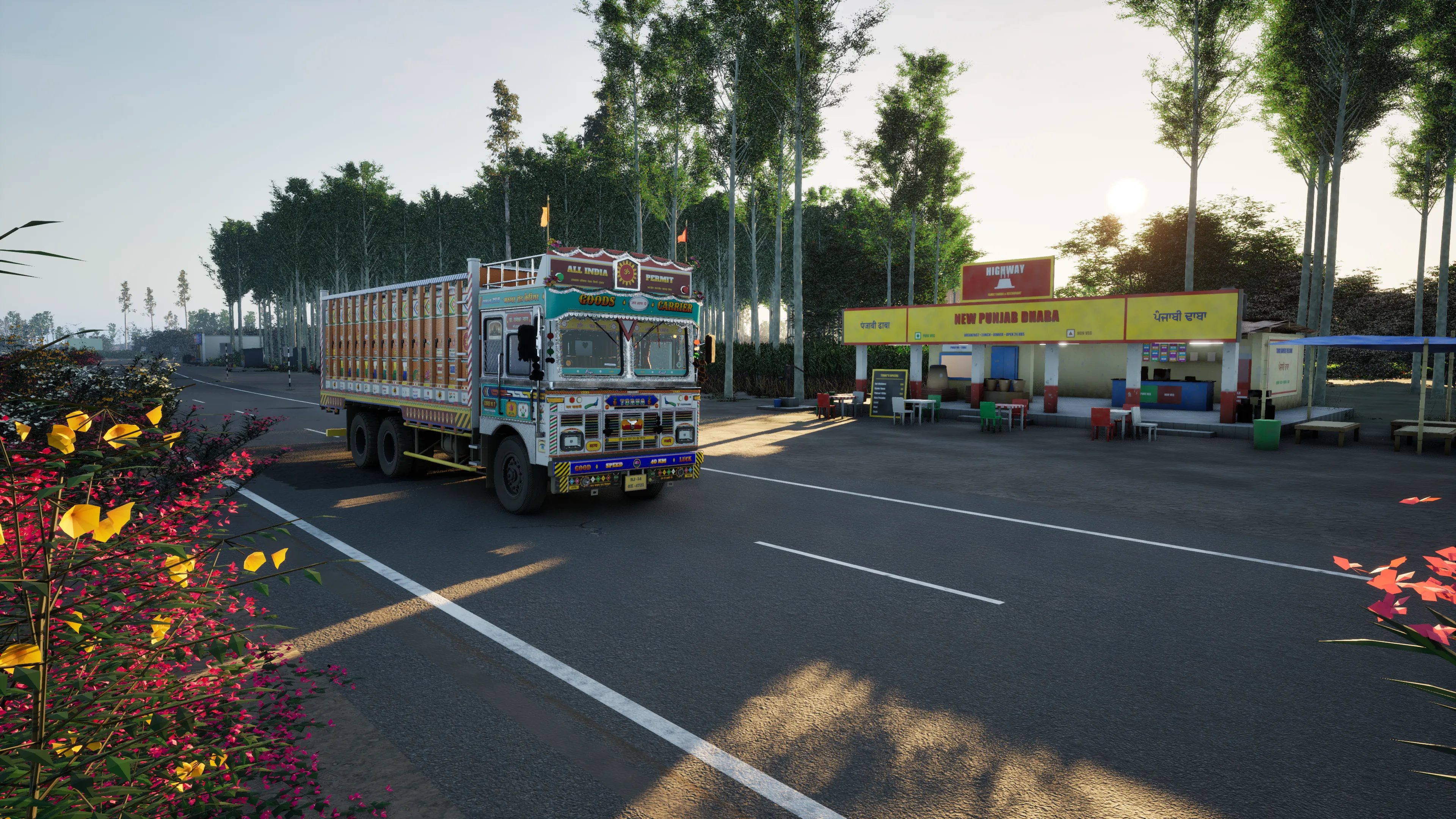 A painted truck on the road beside the yellow New Punjab Dhaba in low evening sun, poplars behind