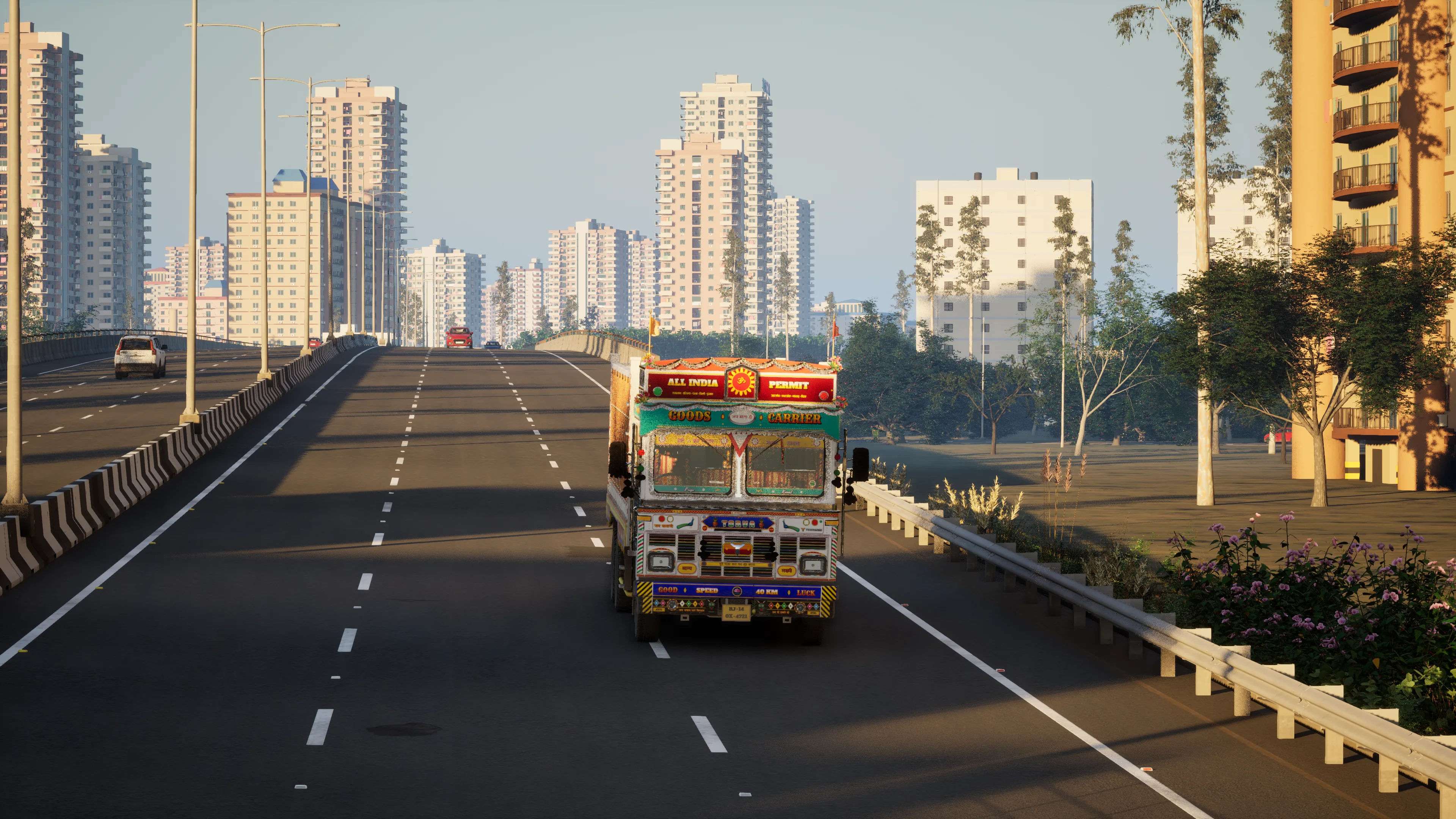 A painted truck on a wide multi-lane road at golden hour, a flyover and a skyline of apartment towers behind it