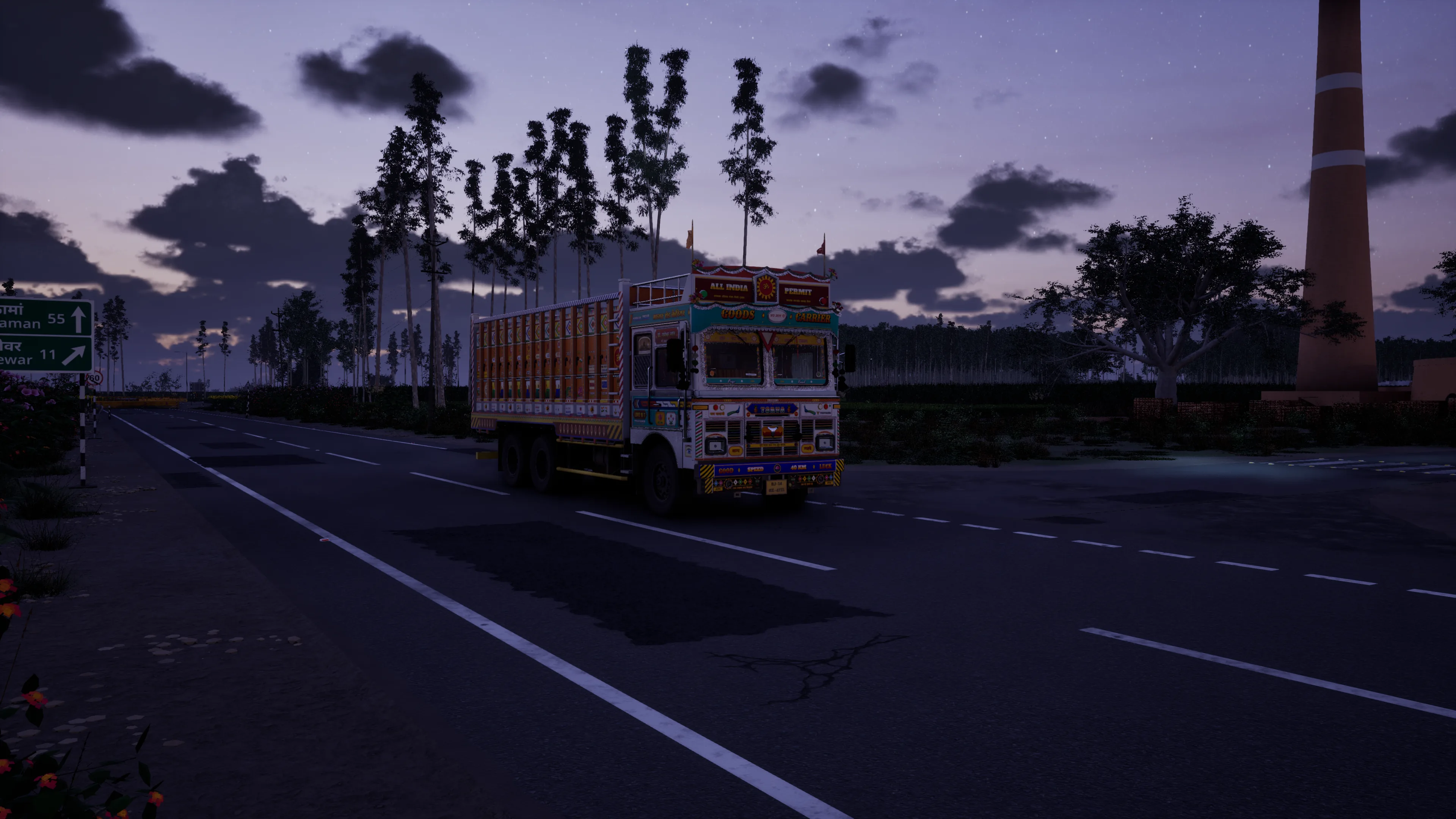 A painted truck on an empty road at dusk, a kiln chimney and tall trees against a violet sky