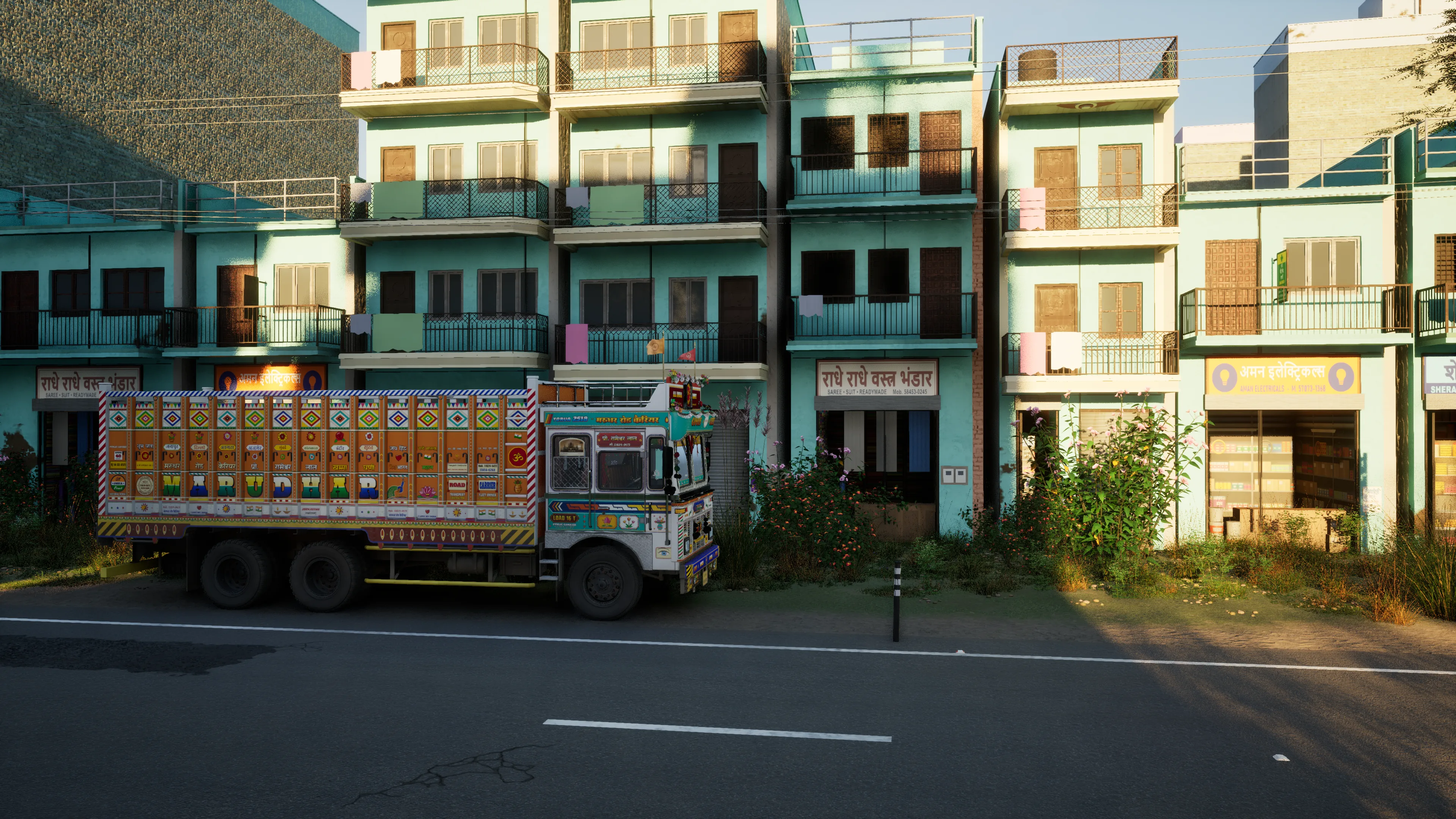 A painted truck parked side-on before a row of turquoise shop-houses with Hindi and English signs, in low evening sun
